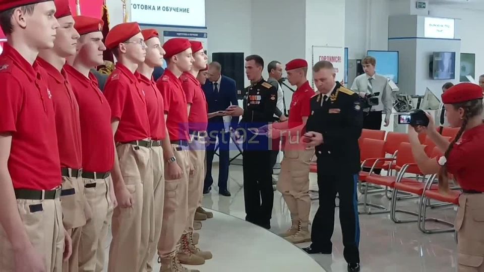 В выставочном зале концерна «Аламаз-Антей» Герой России Владислав Головин вручает юнармейцам значки